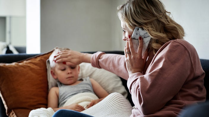 A parent is checking a child’s temperature at home.