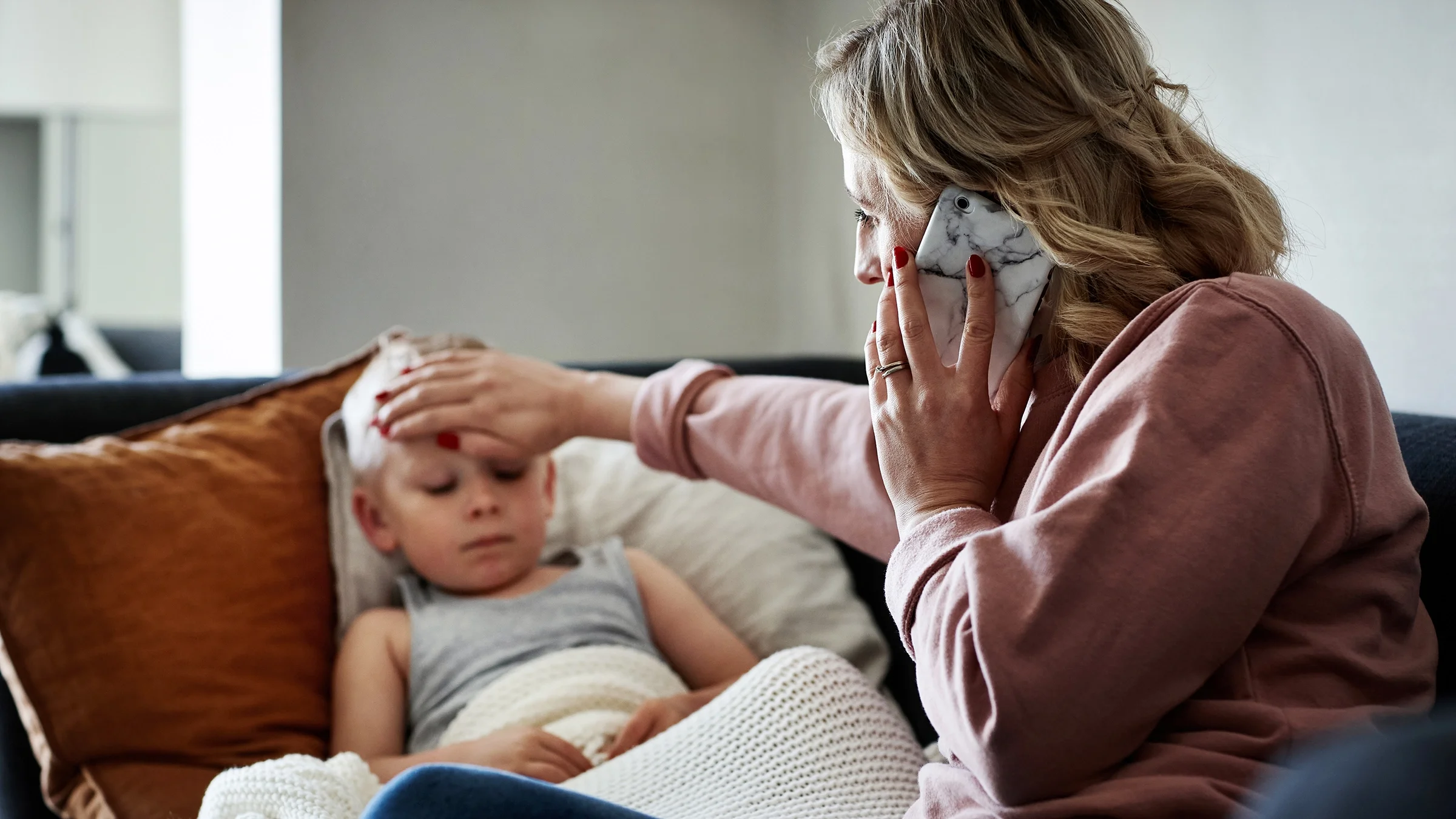 A parent is checking a child’s temperature at home.