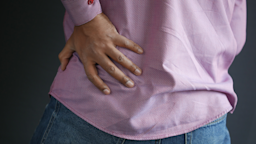 A man is holding his lower back in a close-up.
towfiqu ahamediStock via Getty Images Plus   