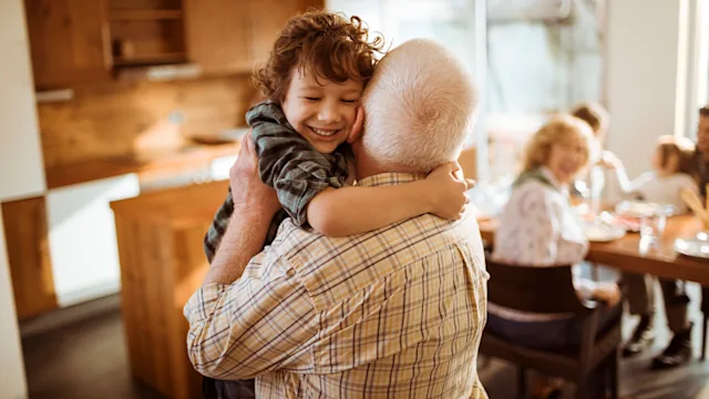 grandfather-hugging-grandson-658137990