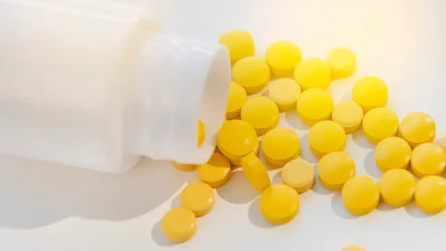 Health: Substance use: bottle of yellow pills spilling-1369026114