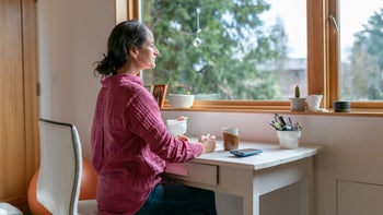 Mental health: Surviror's guilt: woman journaling at desk 1412972215