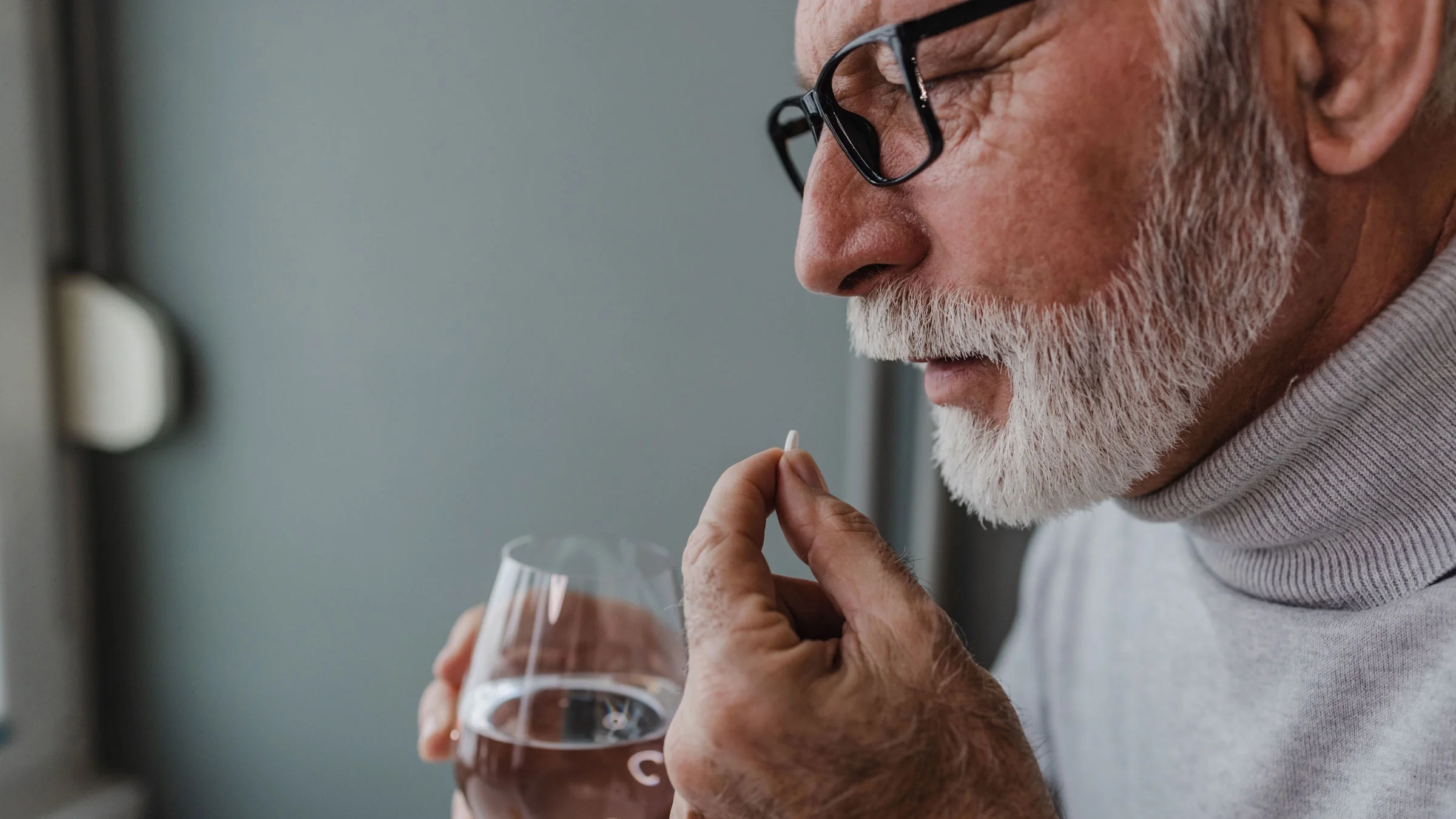 Senior man takes medicine.