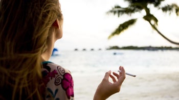 Dermatology: woman smoking a cigarette on the beach 108271485