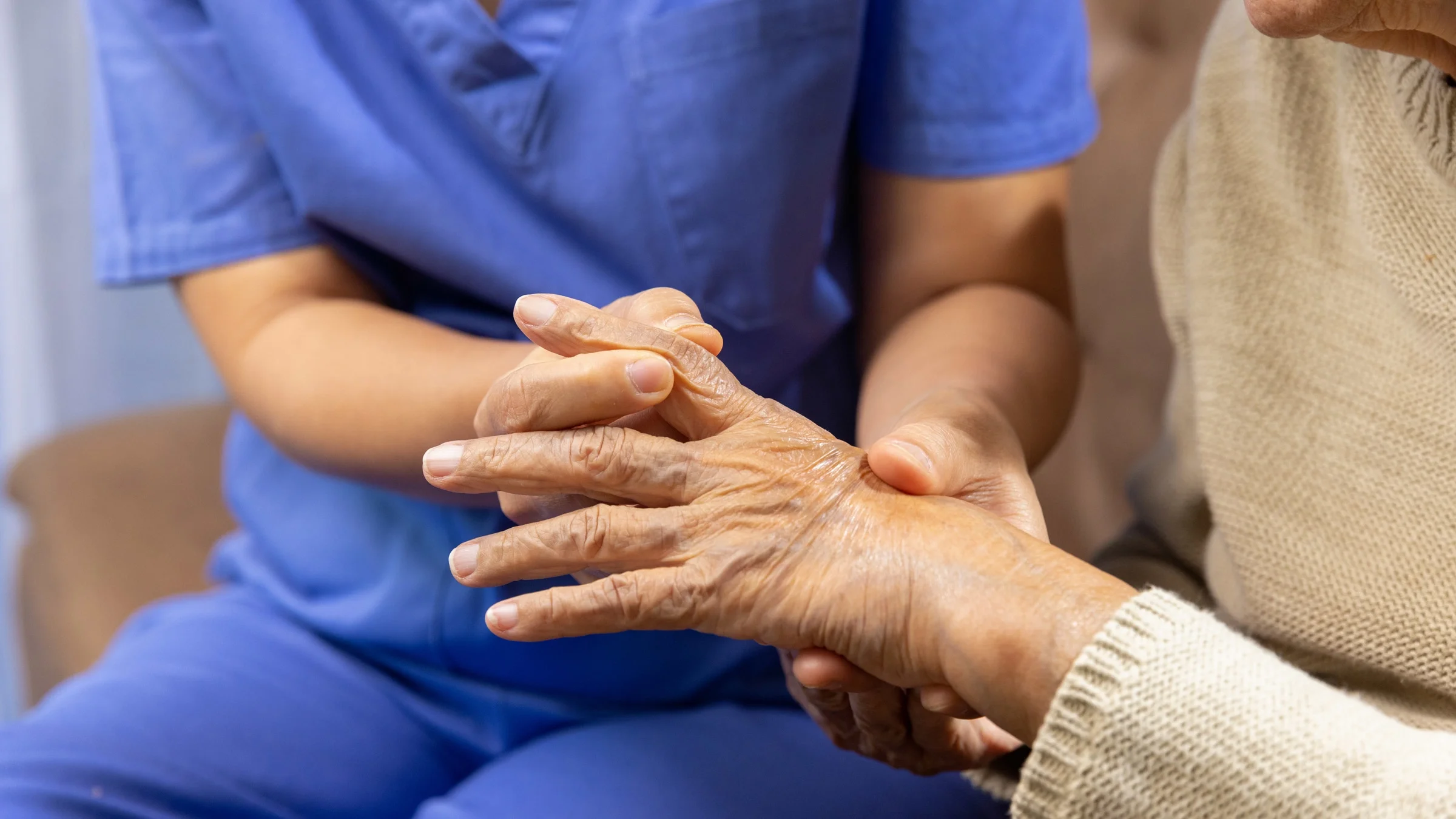 A HCP holding a hand with arthritis.