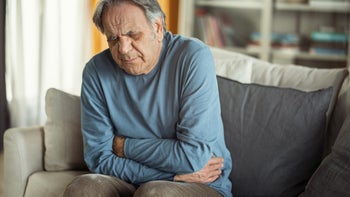 constipation: senior man with stomach pain 1450113888
