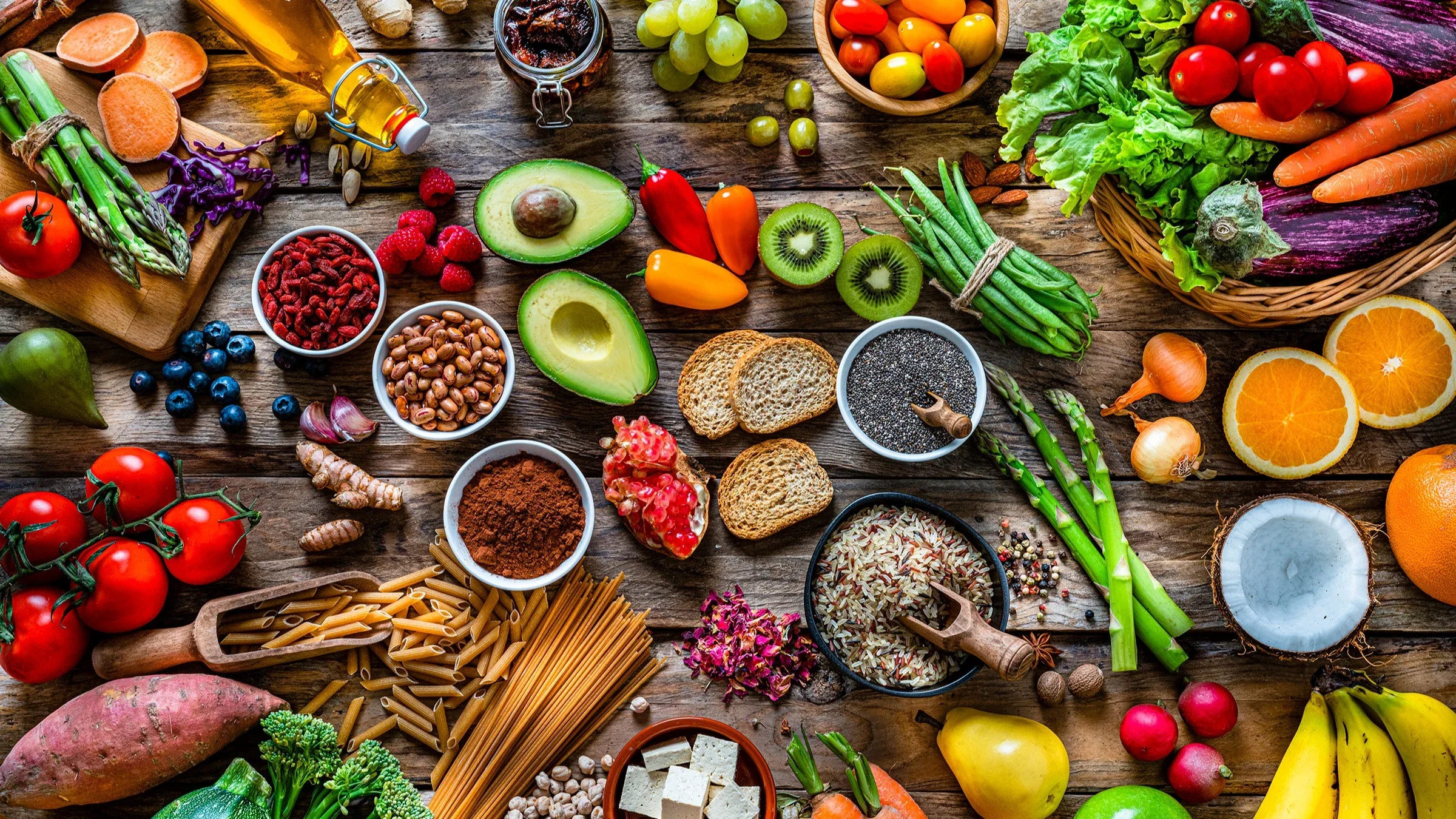 Overhead shot of various fruits, vegetables, and grains on a wooden table.
fcafotodigital/E+ via Getty Images