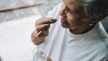 propranolol: senior woman taking medication 2200416949
