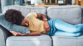 woman abdominal pain couch 1306632928