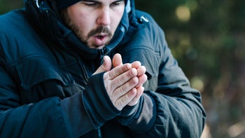 environmental: man warming his hands 1058823588