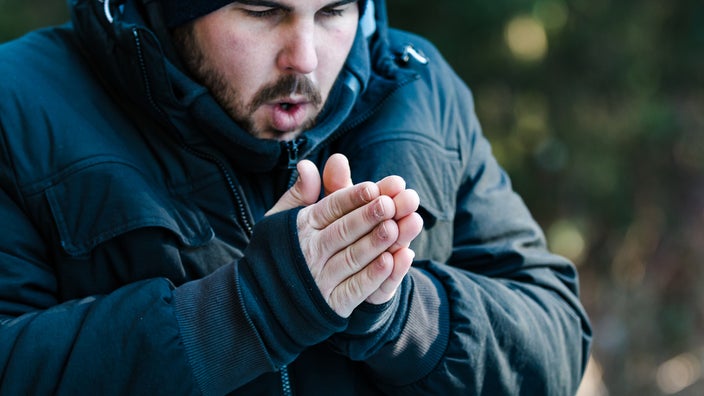 Man warming his hands with his breath.