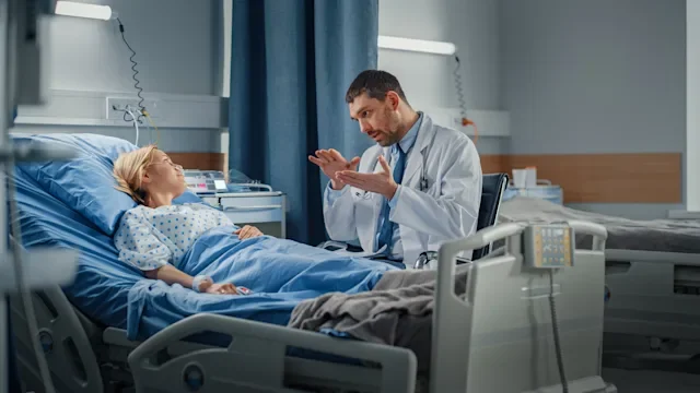 Gallstones: Galbladder removal: doctor explain something to woman in hospital bed-1321692342