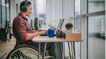 Health: Health insurance: man in wheelchair working at desk 1319810505