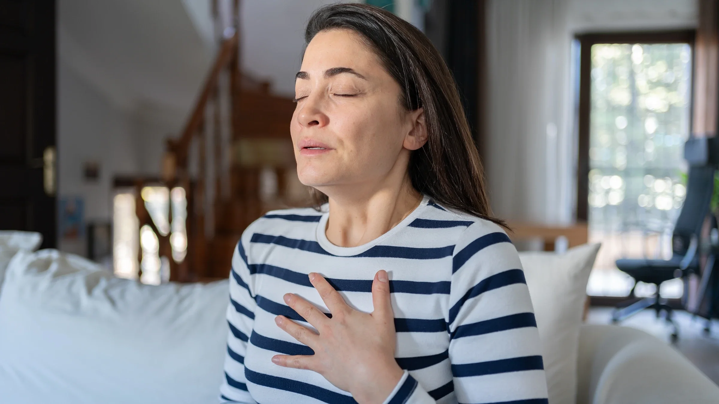 A woman is taking a deep breath.