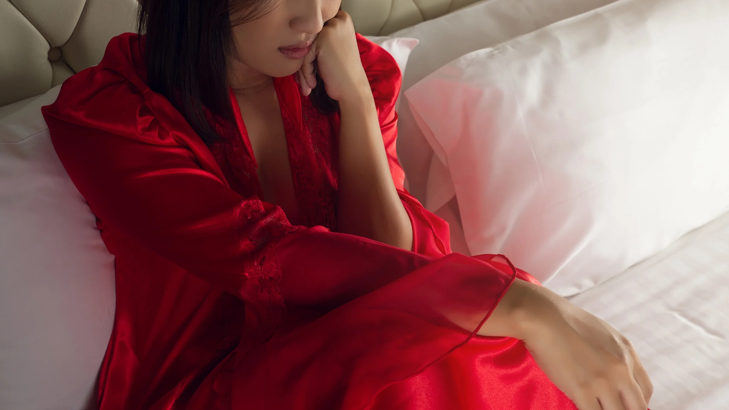 A cropped shot of someone looking sad in their bed.