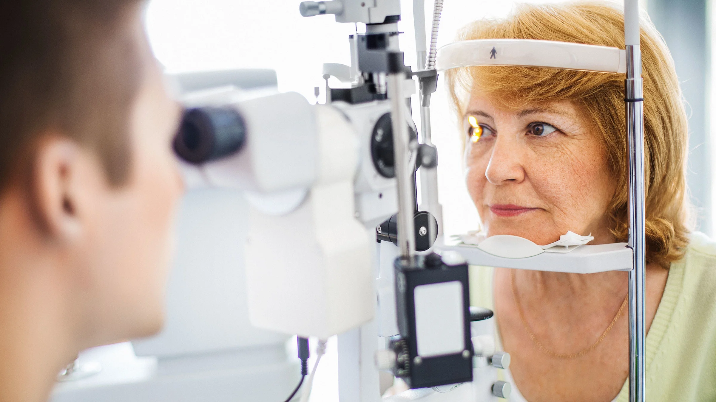 A person is having their eyes examined by a healthcare provider.