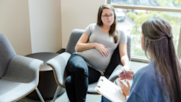 Pregnant woman speaking to a counselor.
SDI Productions/E+ via Getty Images Plus