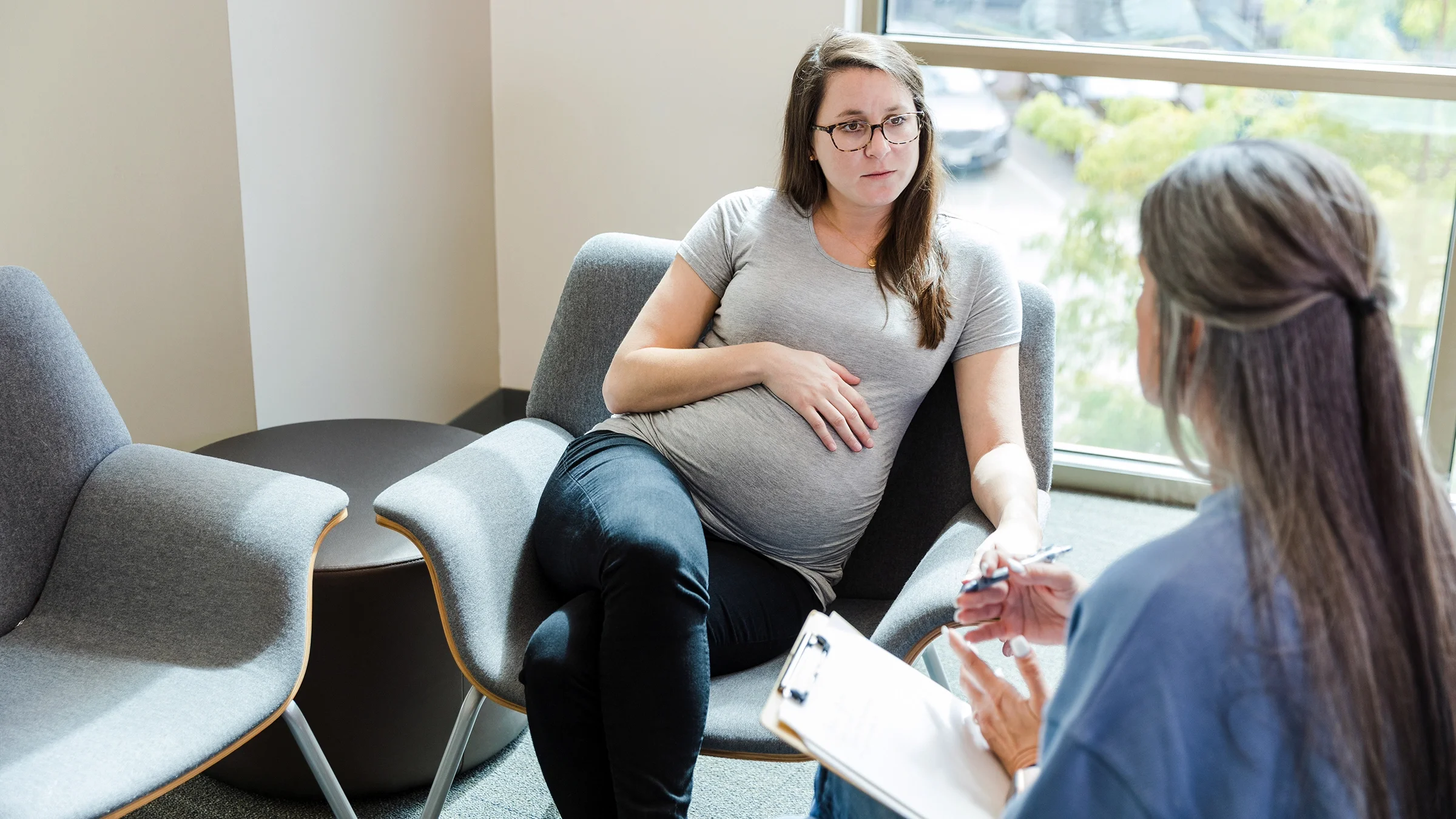 Pregnant woman speaking to a counselor.