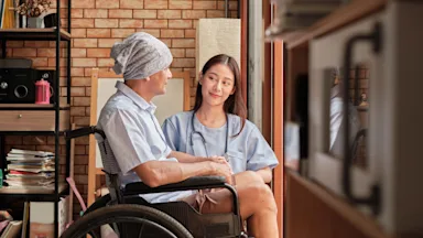 A HCP talking to a cancer patient in wheelchair.
Tigercat_LPG/iStock via Getty Images Plus 