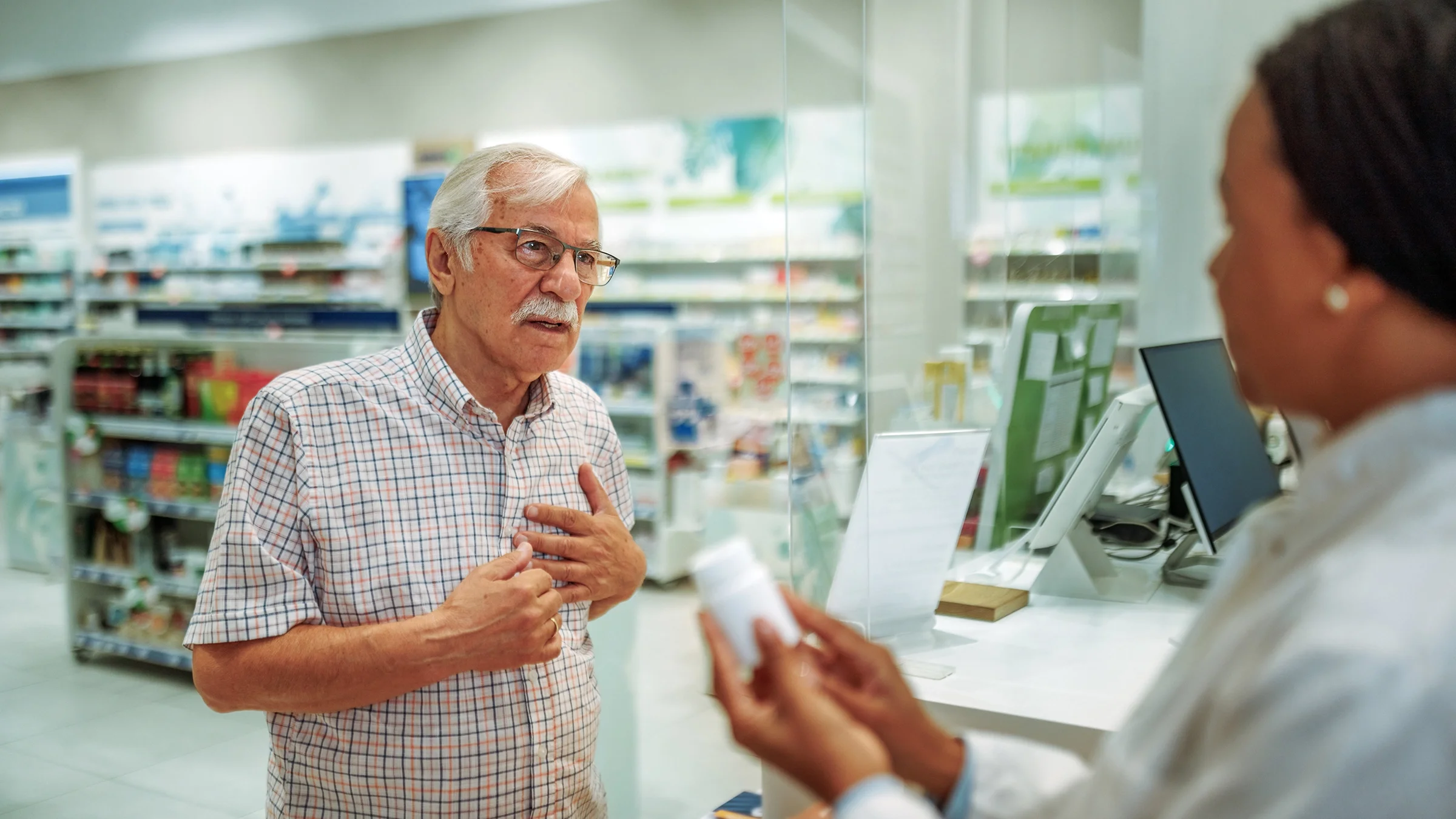 A man speaks to a pharmacist about heart medication.