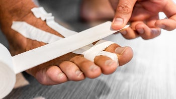 Musculoskeletal: Foot: closeup man taping broken toe 1384045437