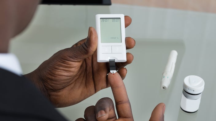 Cropped shot of a man using a glucometer to test his blood sugar levels.