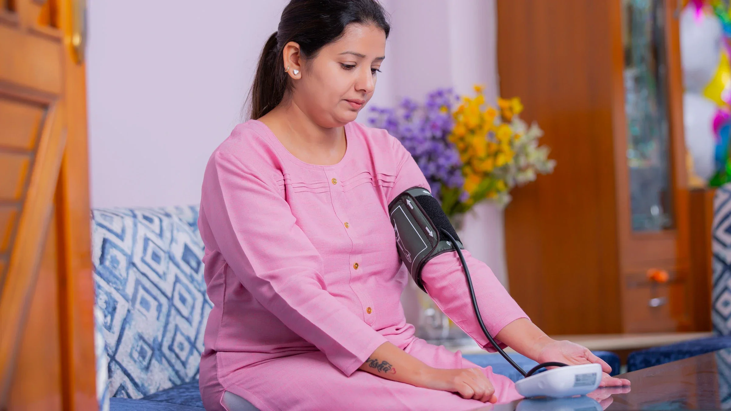 A woman checking her blood pressure with a blood pressure cuff.
Deepak Sethi/iStock via Getty Images