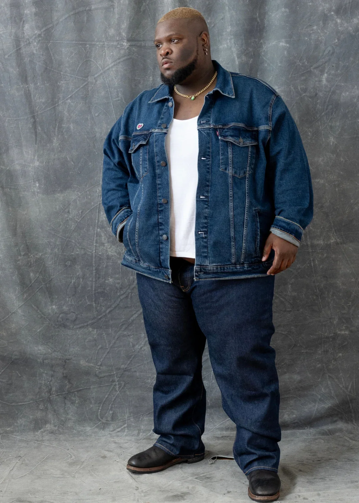 Tevin Evans is pictured in a fashion photo shoot, wearing jeans and a denim jacket.