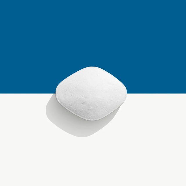 White, rounded square-shaped pill on a blue and white background.