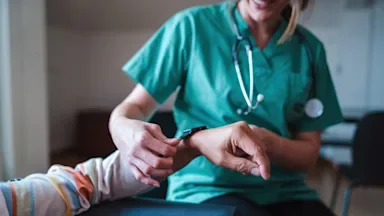 Digital health: doctor putting smartwatch on patients arm 1363170011