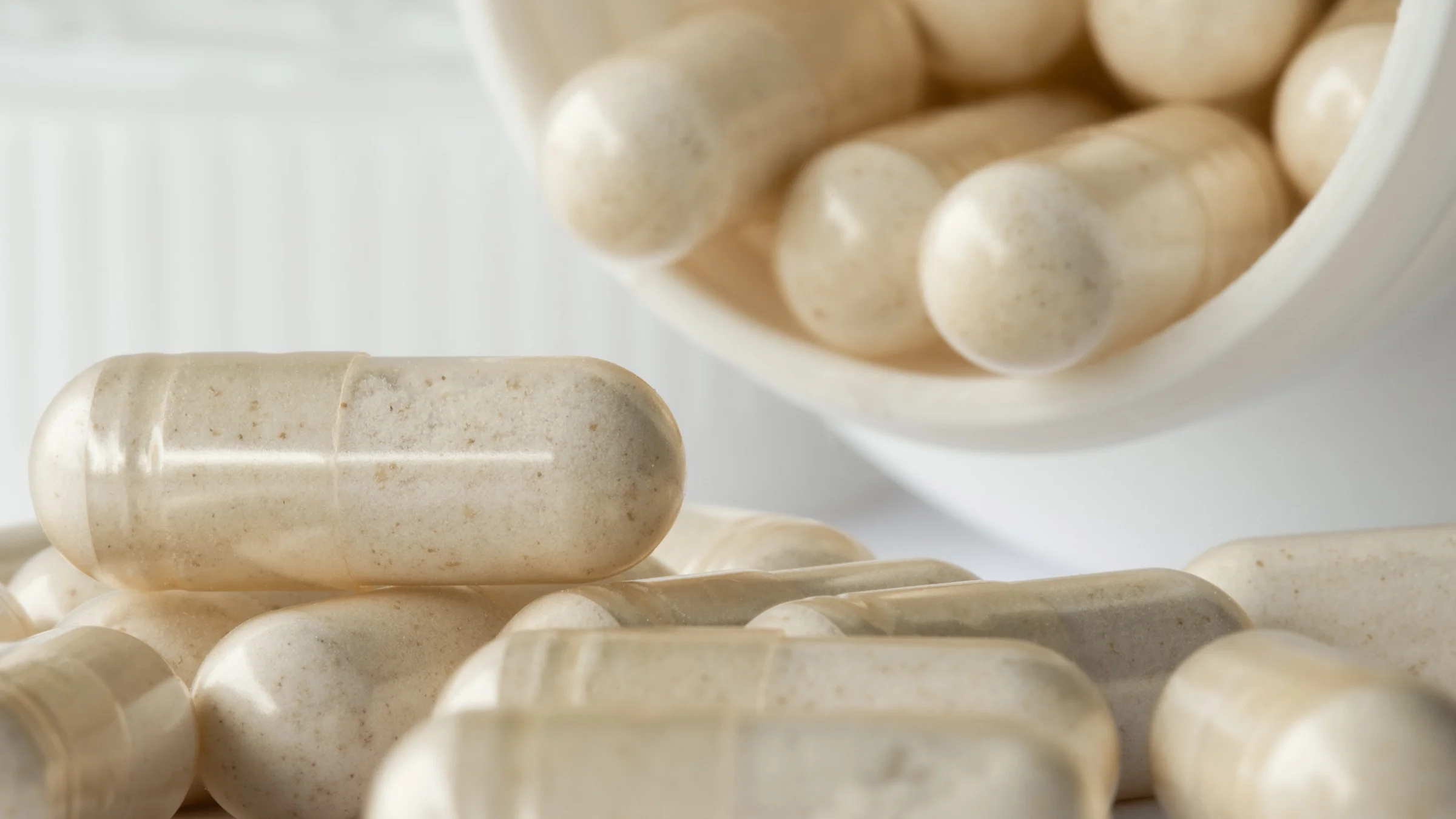 A close-up image shows tan supplement capsules.