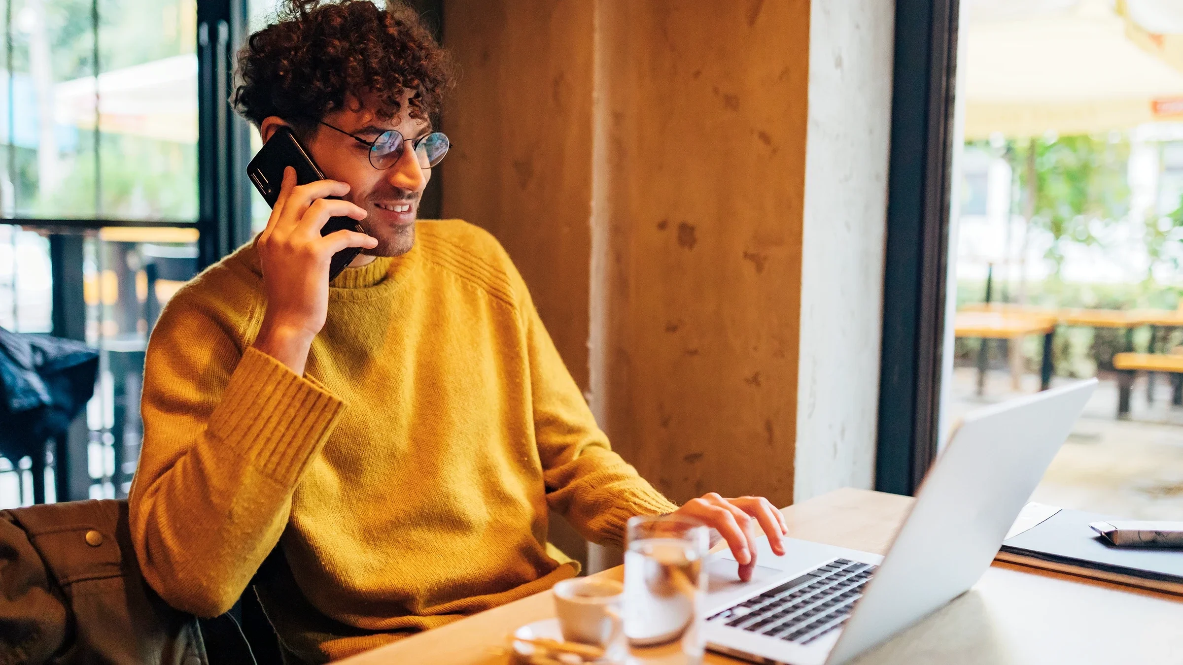 Man on the phone and looking at his laptop