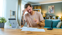 A man doing finances at home.
LordHenriVoton/E+ via Getty Images