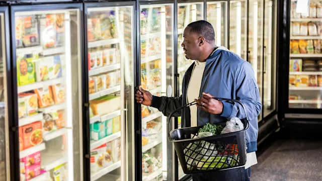 diet nutrition: man shopping in frozen food aisle 1198654826