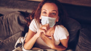 COVID: Woman with mask in bed