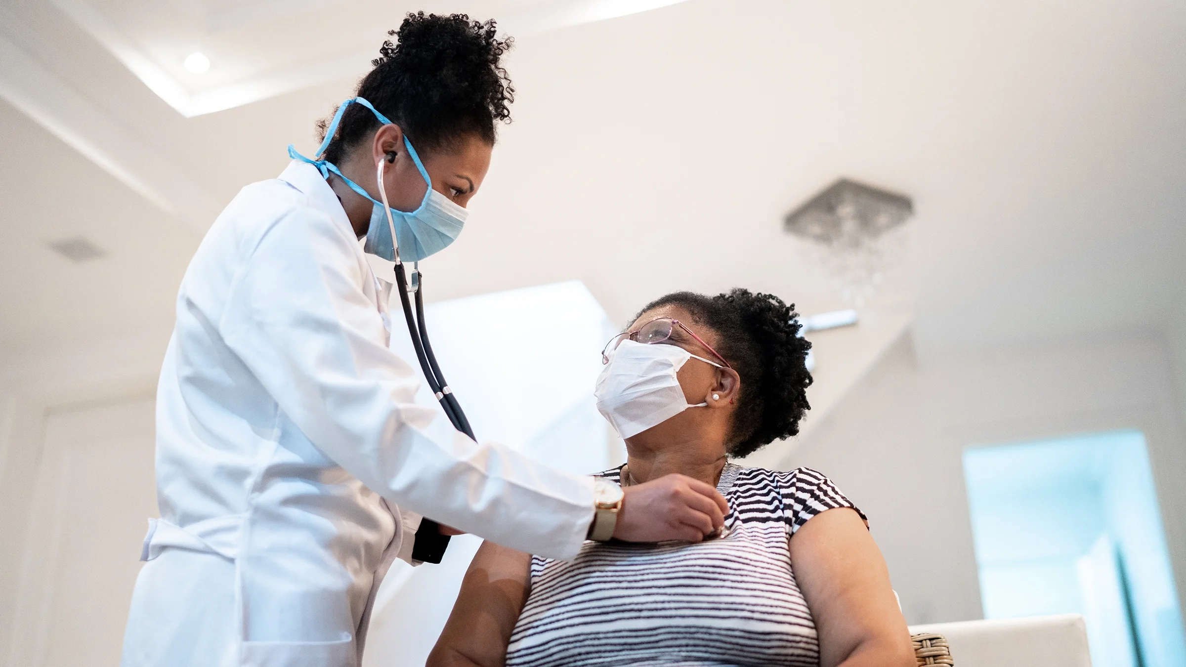 A doctor checks a patient with a stethoscope.