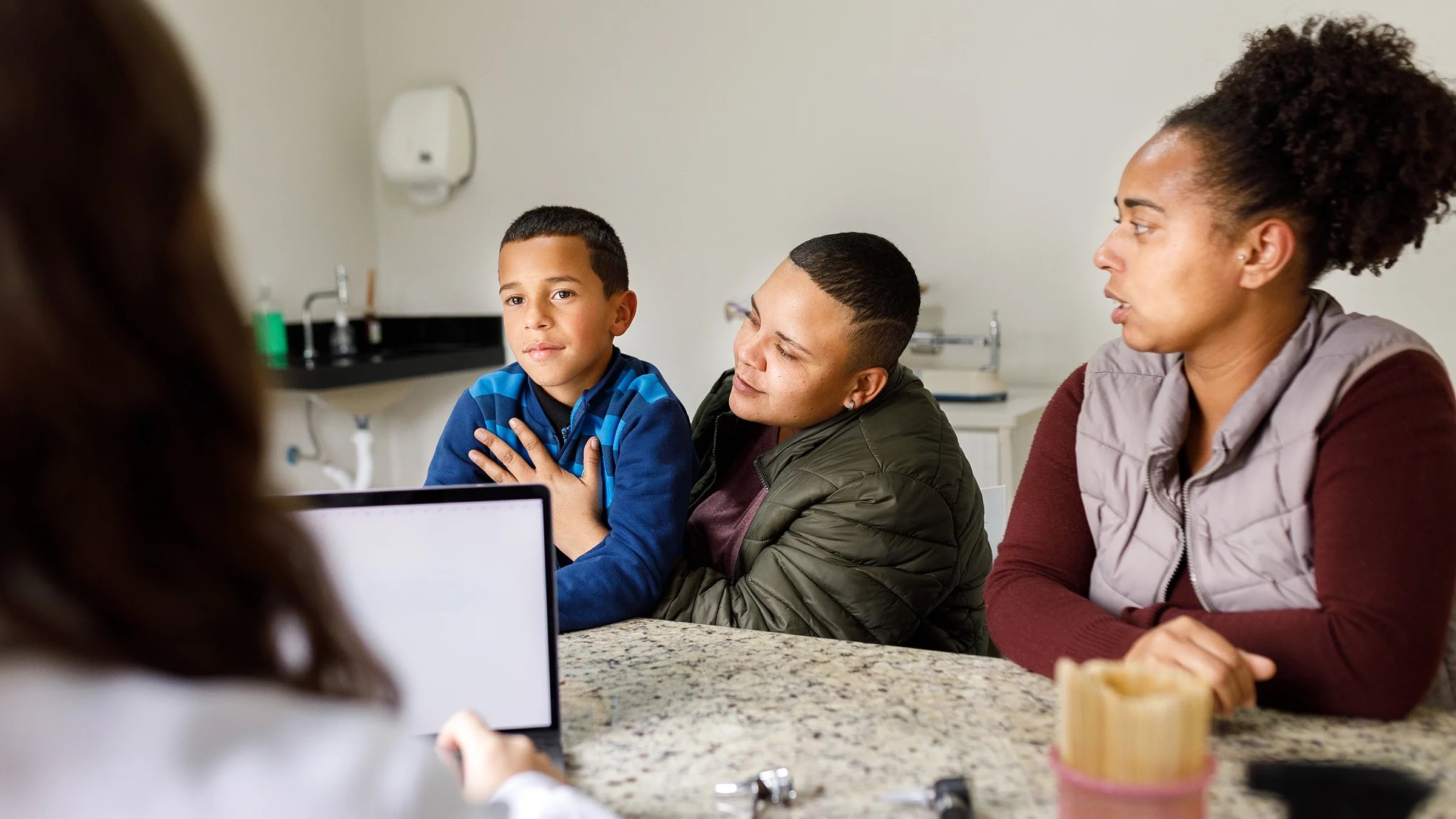 A mother is explaining her son's symptoms to their pediatrician.