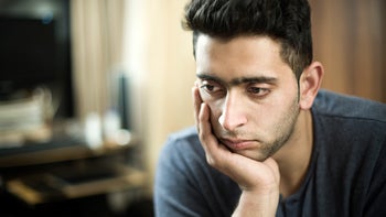 Mental Health: man resting head on hand thinking 506326438