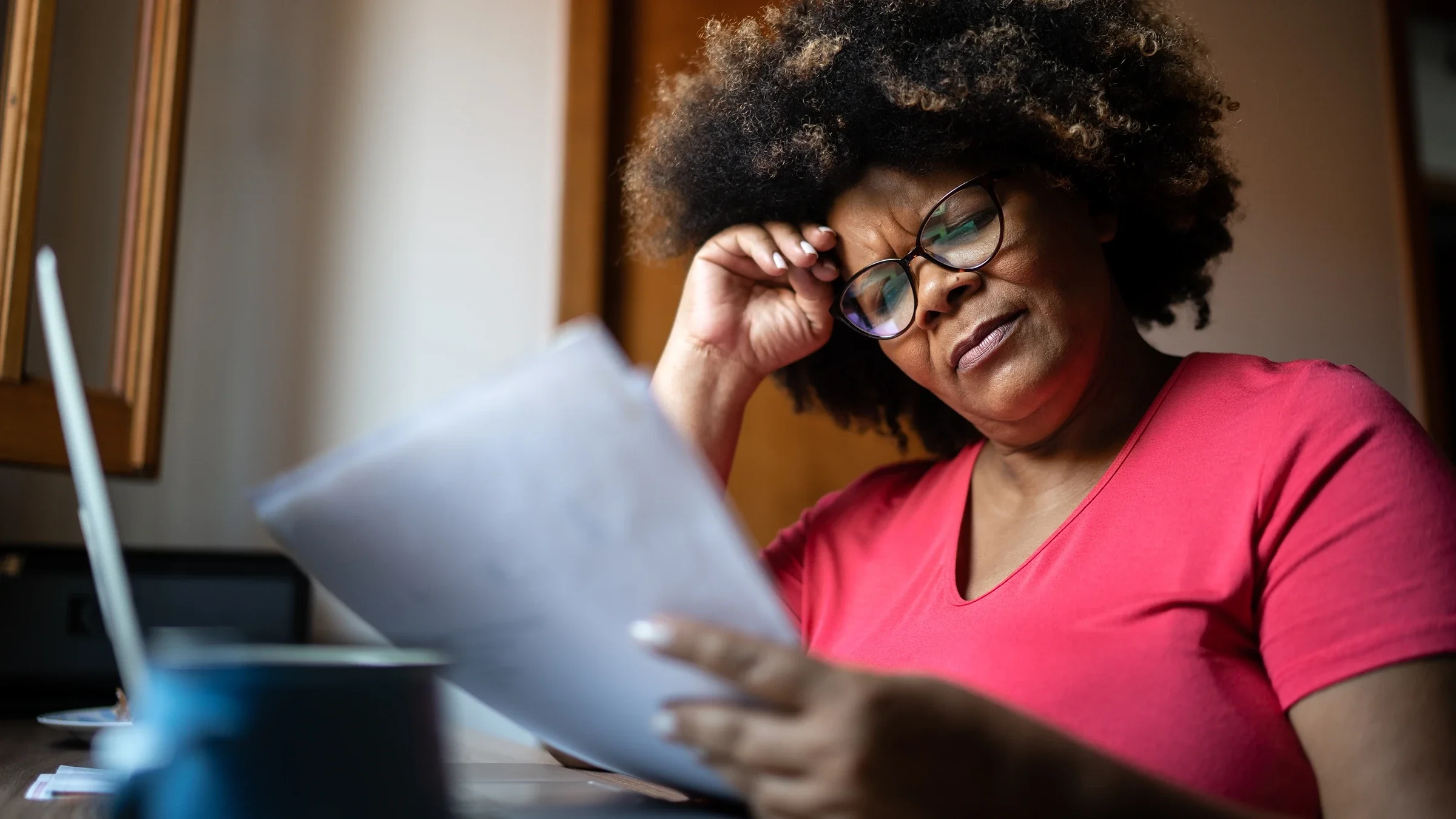 A woman appears puzzled while reading paperwork.