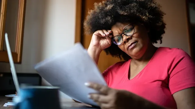 Medicaid: woman reading paperwork 1290882693