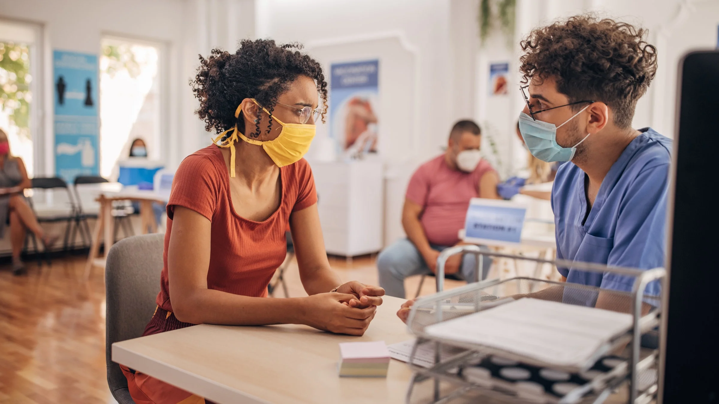 A patient talking to their doctor at a vaccine center.