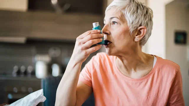 Asthma: Inhaler: woman using inhaler 1153440302