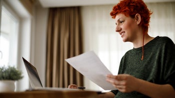 Insurance: High deducible: typing at desk holding document 941817686