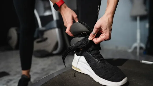 movement exercise: closeup woman adjusting ankle weight 1452012954