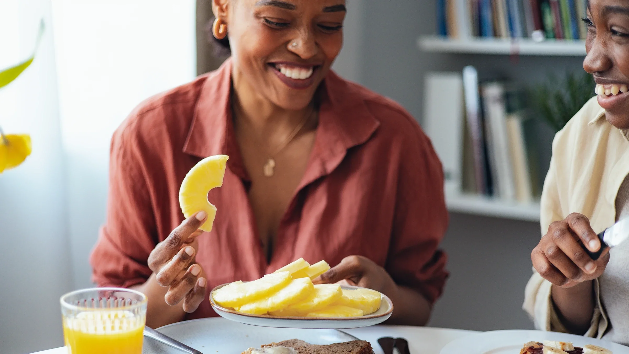 Woman holding a plate of sliced pineapple