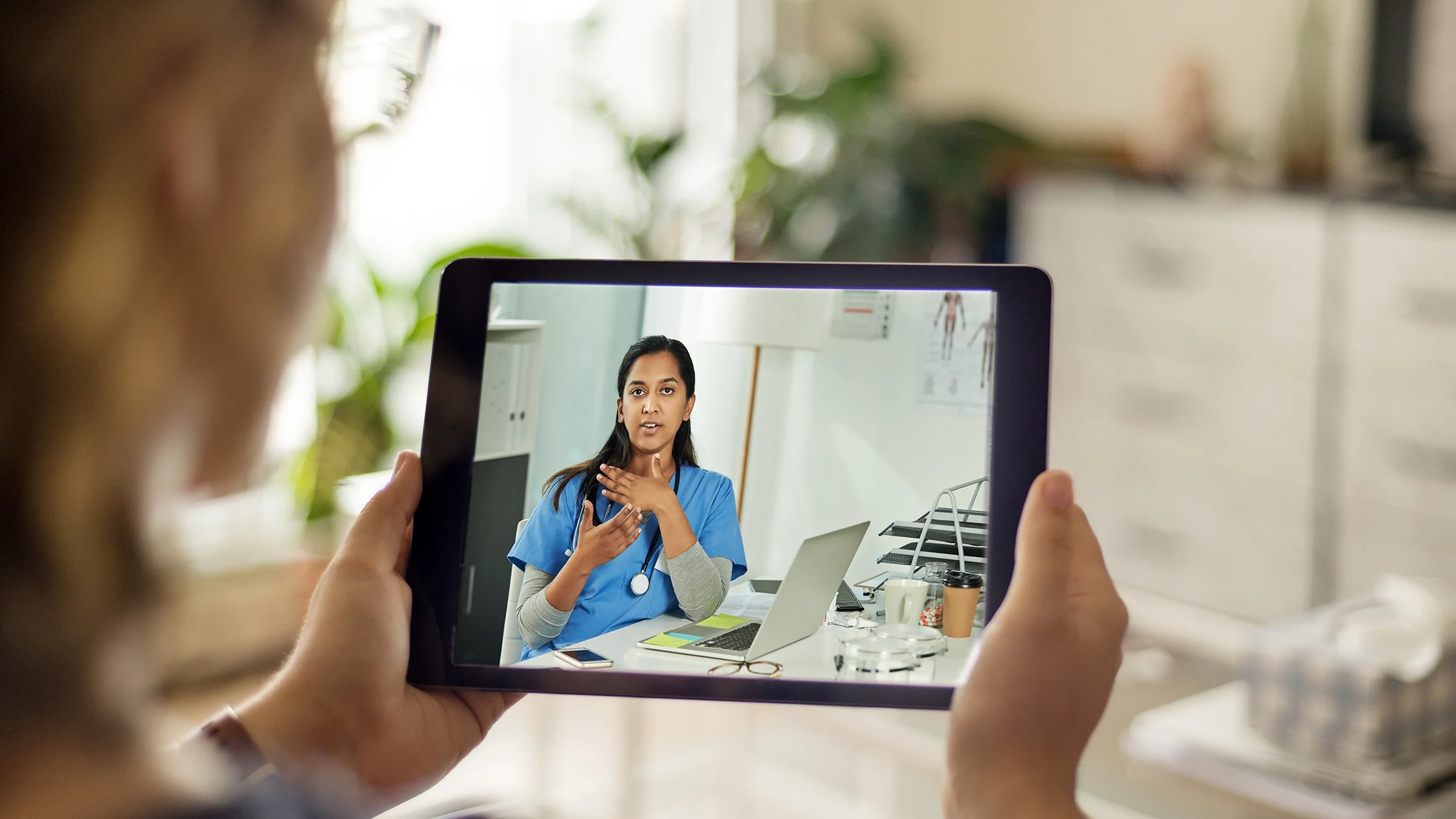 An older adult is talking during a telehealth appointment.