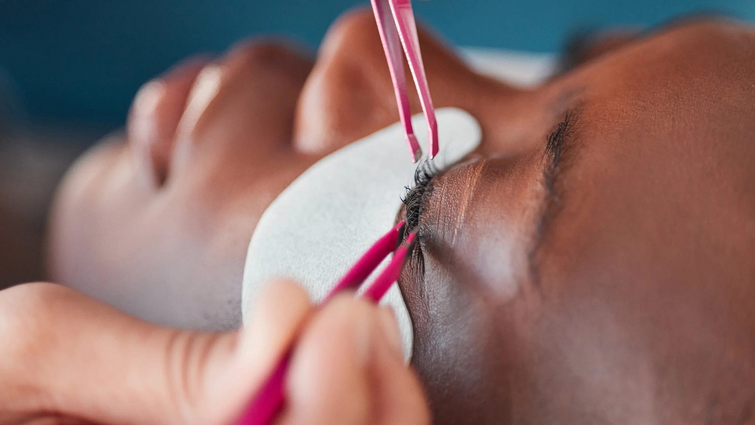 Close-up applying eyelash extensions.