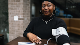 A healthcare provider tests a woman’s blood pressure in an exam room.
Fly View Productions/E+ via Getty Images