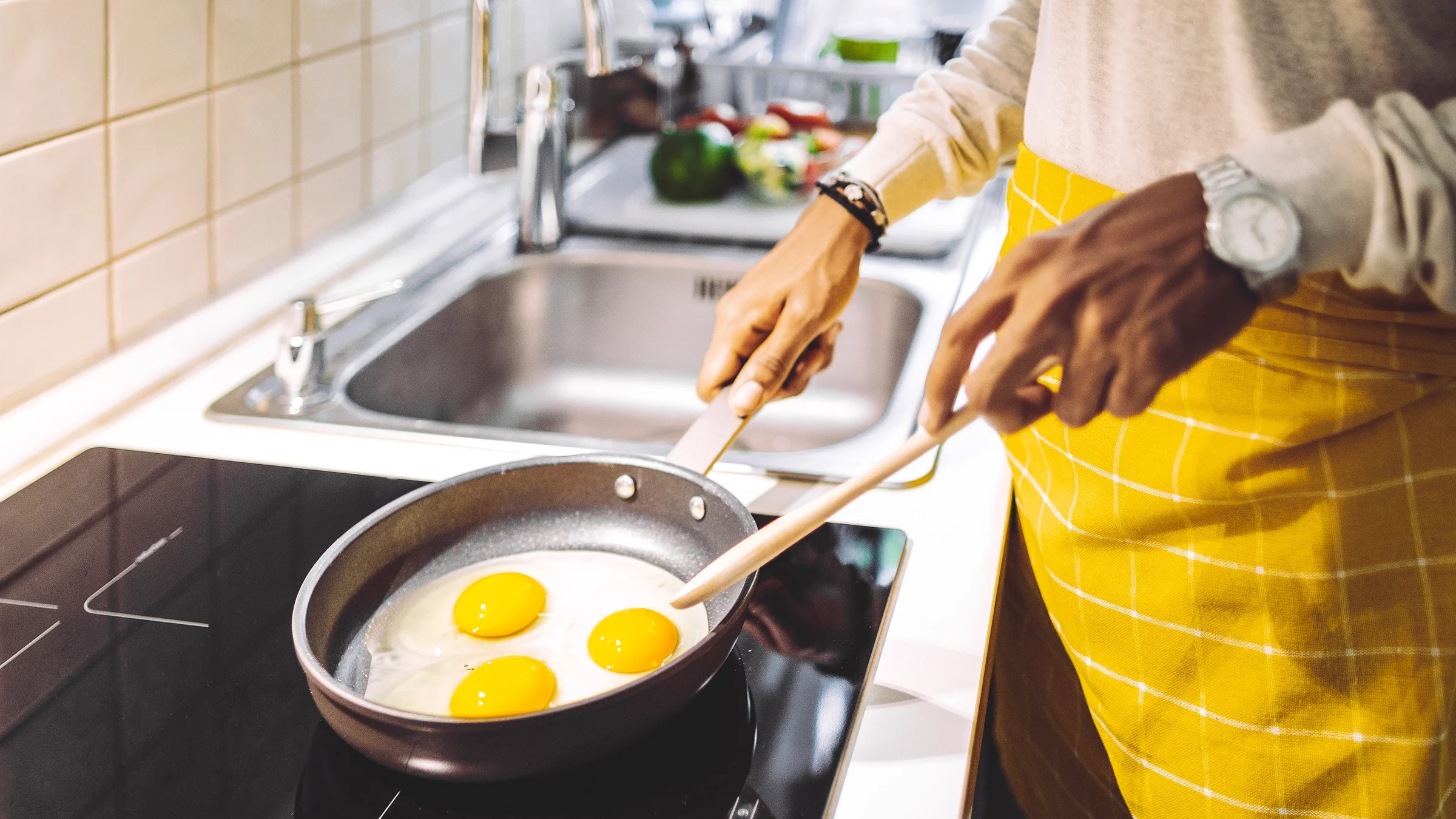 Close-up person cooking eggs.