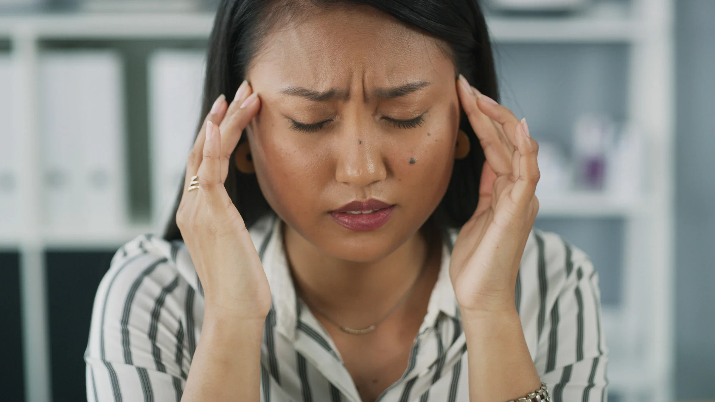 A person with a headache rubbing their temples.
Adene Sanchez/E+ via Getty Images